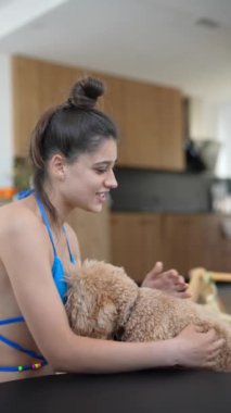 Genç bir kadın, modern bir yuva ortamında sevimli kanişiyle samimi ve samimi bir anın tadını çıkarıyor.