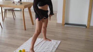 Bir kız yoga yaparken hiç zorlanmaz, esnekliğini arttırır ve sakin bir mekanda odaklanır.