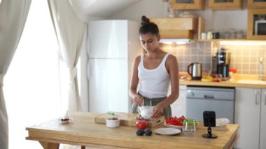 Bir kadın şık mutfağında sağlıklı ve lezzetli bir yemek için taze, besleyici malzemeler hazırlamakla meşgul.