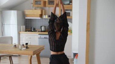 Şık bir mutfakta, bir dansçı zarifçe poz verir, yaratıcılığın ve hareketin özünü güzel bir şekilde somutlaştırır.