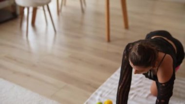 Huzurlu bir ev ortamında yoga yapan bir kadın esnekliğini ve genel olarak sağlığını geliştirir.