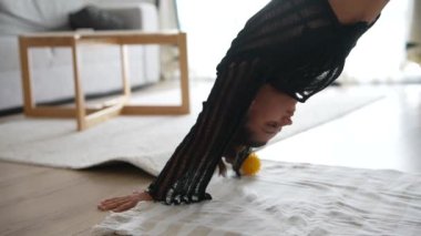 Bir kişi amuda kalkarak poz veriyor, elinde limonla dengede duruyor, dayanıklılık ve esneklik gösteriyor..