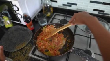 Renkli sebzeler tavada soteleniyor, canlı ev yemeği yetenekleri sergiliyorlar.