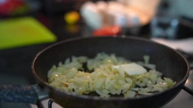 Taze soğanlar tavada soteleniyor, lezzetli bir yemek pişirme süreci gösteriyor.