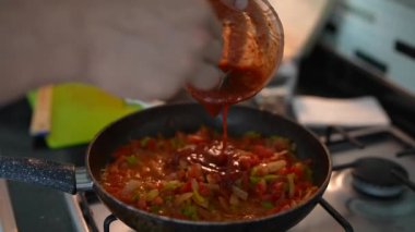 Yetenekli bir şef canlı sebze tavasına aromalı sos döker. Renkli yemek yapma teknikleri sergiler.