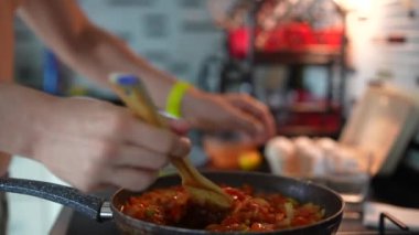 Tavada canlı domates sosu karıştıran bir insan. Yemek meraklıları ve aşçılık ilhamları için mükemmel..