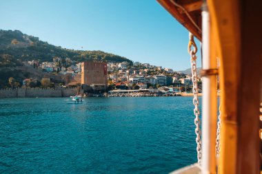 Güzel ve pitoresk bir kıyı manzarası sakin mavi sularla birlikte tarihi bir kuleyi gözler önüne seriyor.