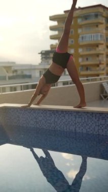 Zarif bir yoga pozu, günbatımında sakin suya zarif bir şekilde yansıyarak, harika bir huzur ortamı yaratıyor.