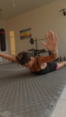 Bir kadın spor salonunda yoğun egzersiz rutinini aktif olarak gerçekleştirir. Güç antrenmanı ve tekniğine odaklanır.