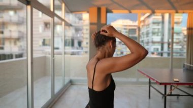 Yetenekli bir dansçı, enerji dolu çağdaş bir iç mekan ortamında etkileyici ve dinamik bir poz sergiler.