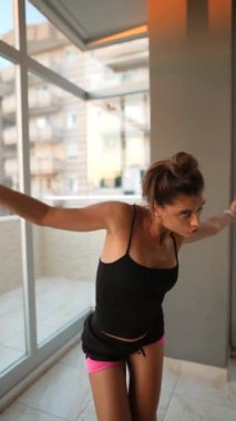 Kendine güvenen genç bir kadın benzersiz fitness stilini kapalı mekanda sergiliyor, rahatlık ve modayı kusursuz bir şekilde harmanlıyor.