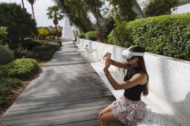 Genç bir kadın aktif ve canlı bir şekilde canlı bir açık hava ortamını keşfederken görsel gerçeklikle iç içe geçiyor.