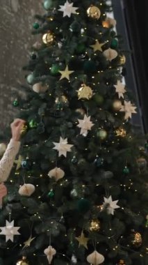 Yeşil ve altın süslemelerle süslenmiş büyüleyici bir Noel ağacı, bayram neşesini yaymak için mükemmel.