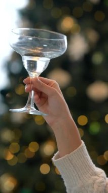 Güzel dekore edilmiş arka planda canlı bir kokteyl bardağıyla parlak ve şenlikli bir kadeh kaldırma.