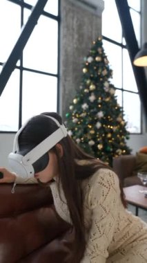 VR kulaklık takan bir kadın şık bir tatil temalı oturma odasında büyüleyici bir sanal gerçekliğe dalmış.