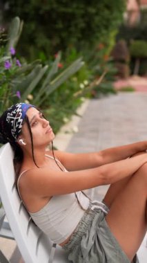 Genç bir kadın, açık havada en sevdiği müzik melodilerini dinlerken huzurlu bir andan zevk alır.