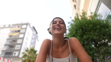 Şık bir başörtüsü takmış neşeli ve neşeli bir genç kadın, dışarıda pozitiflik ve mutluluk saçıyor.