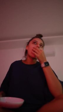 Genç bir kadın, gündelik ve davetkar bir ortamda, çok çeşitli duygular ifade ederken, zamanının tadını çıkarıyor.