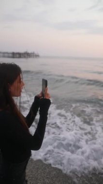 Genç bir kadın inanılmaz sakin bir günbatımı anında kumsalda güzel anılarını yakalıyor.