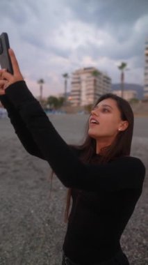 Fırtına bulutları tepemizde toplanırken genç bir kadın heyecanla fotoğrafları yakalıyor. Merakını ve doğallığını yansıtıyor.