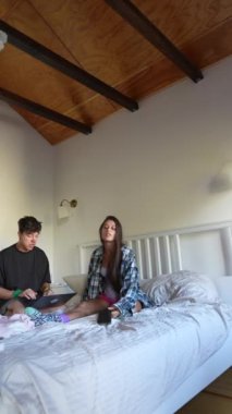 Sıcak bir yatak odası ortamında rahat ve rahat bir sabahın tadını çıkaran yakın dostların neşeli bir sahnesi.