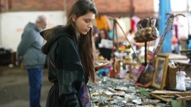 Genç bir kadın ilginç bir şekilde antika pazarında eşsiz eşyalar karıştırıyor, antika hazineler sergiliyor..