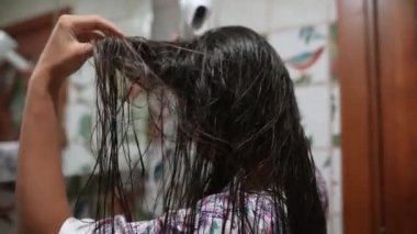 Bir kadın saçlarını parlak renkler ve büyüleyici bir dekor sergileyen güzel döşenmiş bir banyoda kurutuyor.