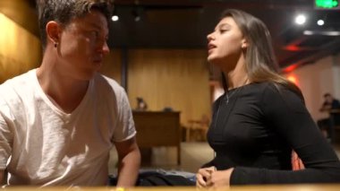 Genç bir çift, samimi bir kafede anlamlı bir sohbete dalıp duygusal dinamiklerini vurguluyor.