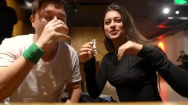 Arkadaşların neşeli ve neşeli bir şekilde kahkahalarını ve mutluluğunu samimi ve samimi bir sosyal ortamda paylaştıkları bir sahne.