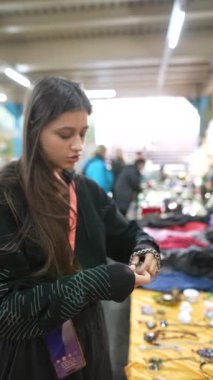 Genç bir kadın renkli bir pazarda ürünleri keşfediyor ve yerel kültüre olan ilgisini gösteriyor.