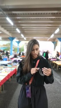 Genç bir kadın hareketli market tezgahlarında gezinerek heyecan verici alışveriş deneyiminin tadını çıkarıyor.