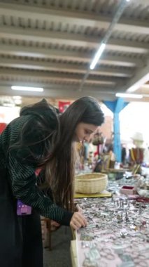 Bir kadın coşkuyla canlı bir vintage pazarı keşfediyor, eşsiz mücevher parçalarını ve bol miktarda koleksiyonu ortaya çıkarıyor.