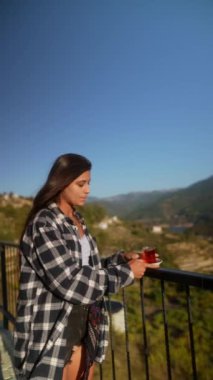 Bir kadın huzurlu ve rahatlatıcı bir anda neşe bulur çarpıcı, resimli manzaraya bakarken.