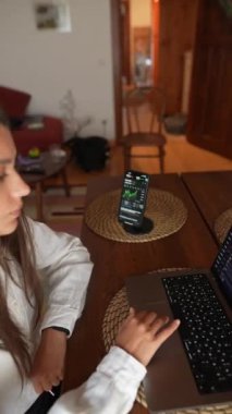 Profesyonel bir gözlemci dizüstü bilgisayar ve akıllı telefon kullanarak hisse senedi piyasası eğilimlerini gözden geçirir.