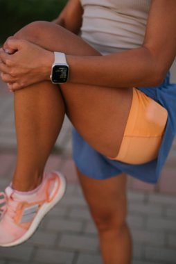 Spor kıyafetleri giyen spor meraklısı bir sporcunun yakın çekimi, spor salonunda aktif olarak çalışıyor.