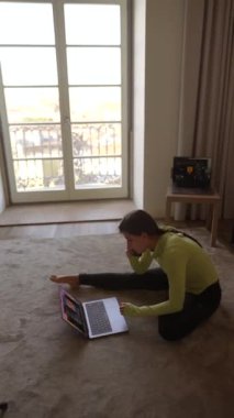 Şık giyimli bir insan dizüstü bilgisayarına odaklanır. Harika bir manzarası olan güzel tasarlanmış bir odada.