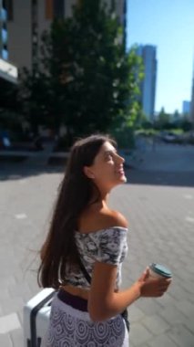 Şık ve modaya uygun bir kadın canlı bir şehir atmosferiyle çevrili iken ferahlatıcı bir içkinin tadını çıkarıyor.