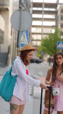 İki şık arkadaş heyecanlı bir seyahat macerasında bavullarıyla keyifli bir anı paylaşıyorlar.