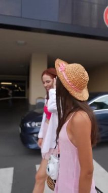 İki arkadaş dışarıda güneşli güzel bir günün tadını çıkarıyorlar, şık yaz modalarını ve eğlenceli havalarını sergiliyorlar.