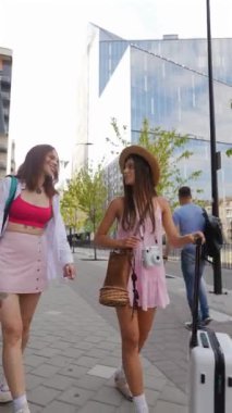 Canlı bir şehirde genç kadınlar, benzersiz modern tarzlarını ve maceraperest havalarını sergileyerek güneşli bir günün tadını çıkarırlar.