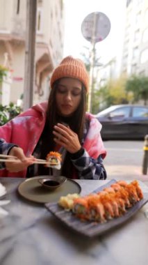 Şehir ortamında rahat bir suşi yemeğinin tadını çıkar. Lezzetli böreklerin tadını çıkarırken rahat bir şekilde giyin.