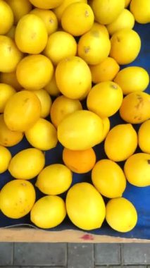 Canlı yeşil ve parlak sarı limonlar hareketli bir yerel pazarda güzel bir şekilde sergileniyor.