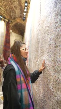 Bir ziyaretçi, tarihi bir müzedeki karmaşık duvar sanatına hayran kalarak kültürel mirası güzel bir şekilde sergiliyor.