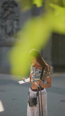 Genç bir kadın neşeli bir şehir ortamında neşeli bir selfie çekerken güneşli bir günün tadını çıkarıyor.