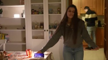 Sıcak ve sıcacık bir mutfakta, genç bir kadın akıllı telefonuyla havanın tadını çıkarırken...