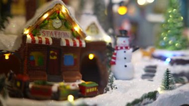 Kar yağışı, mutlu bir kardan adam ve sıcak, aydınlık evler, neşe ve sıcaklık getiren büyüleyici bir kış köyü.