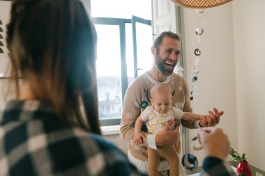 Neşeli bir baba, sevimli bebeğiyle sıcak ve davetkar bir atmosferde eşsiz bir bağ kurar.