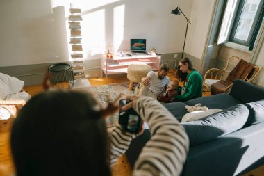 Parlak ve modern bir oturma odası ortamında eğlenceli etkileşimlerle dolu sıcak bir aile sahnesi.