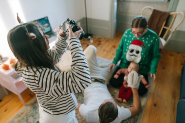 Neşeli bir aile, canlı bir festival sırasında Noel kıyafeti giymiş bir bebekle güzel anılar yakalar.