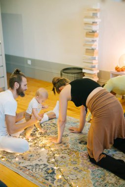 Sıcak, sevgi dolu, sıcak bir ortamda bebek varlığının tadını çıkaran aile içi etkileşimin yürek ısıtan bir sahnesi.